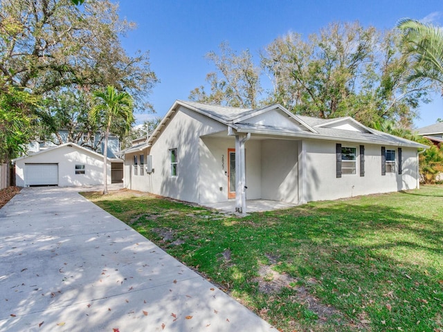 view of home's exterior with stucco siding, an outbuilding, a lawn, driveway, and a garage