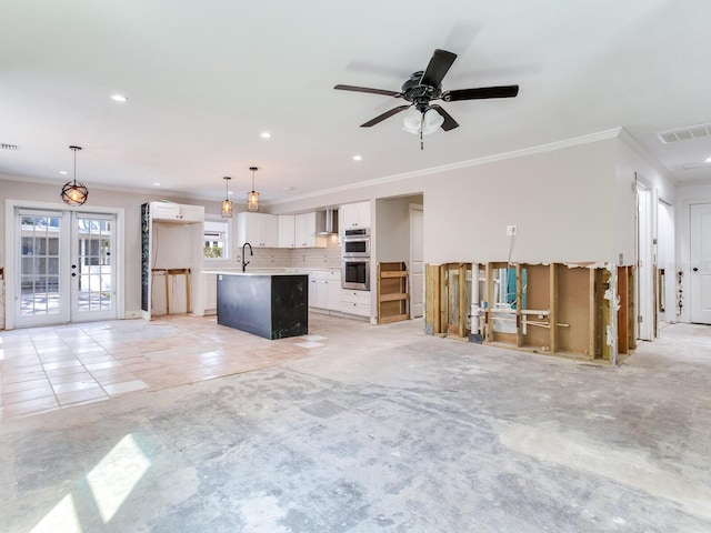 unfurnished living room with a sink, visible vents, ornamental molding, and french doors