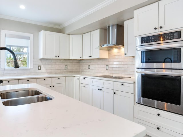 kitchen with stainless steel double oven, a sink, crown molding, black electric stovetop, and wall chimney exhaust hood