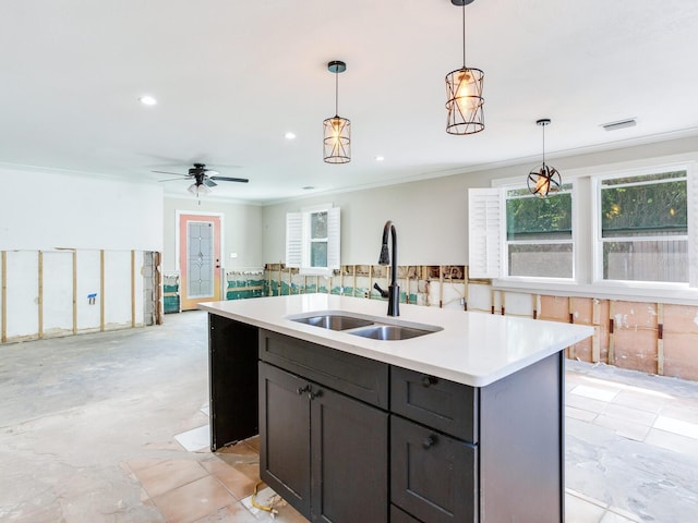 kitchen with hanging light fixtures, light countertops, a wealth of natural light, and a sink