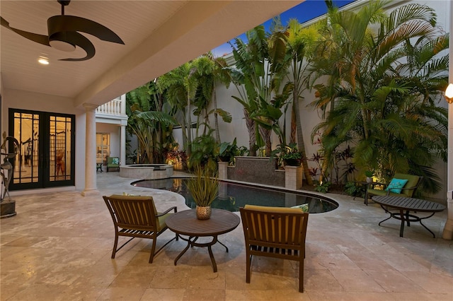 view of patio / terrace with a ceiling fan and a pool with connected hot tub