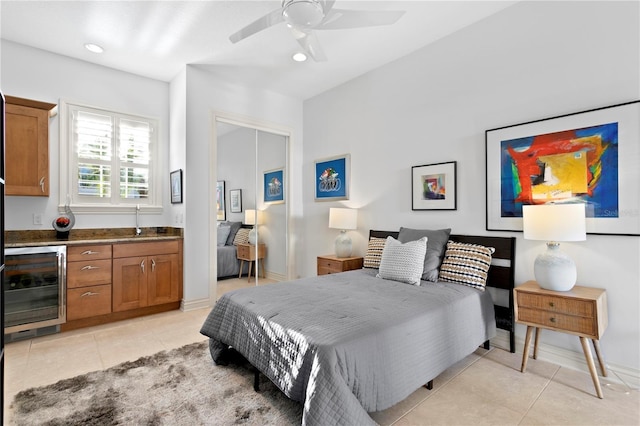 bedroom with light tile patterned floors, beverage cooler, and baseboards