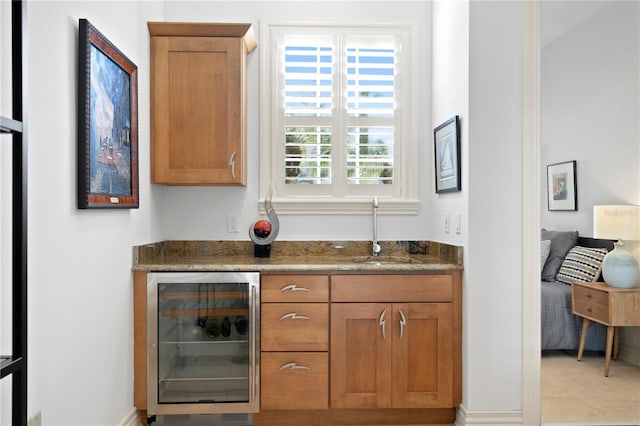 bar featuring wine cooler, bar area, and a sink