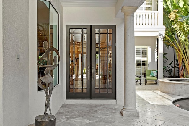 view of exterior entry with french doors, a patio area, and stucco siding