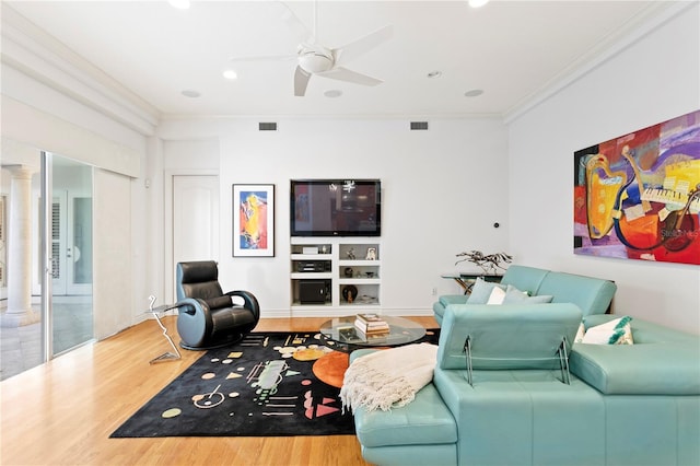 living room with visible vents, ornamental molding, wood finished floors, ceiling fan, and ornate columns