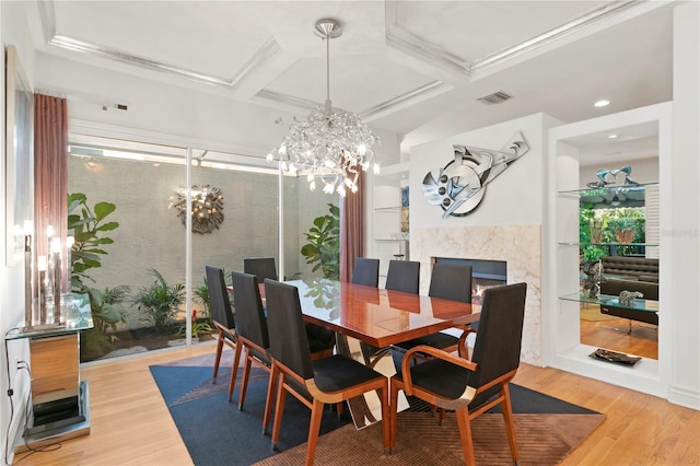 dining space featuring wood finished floors, visible vents, coffered ceiling, and a chandelier