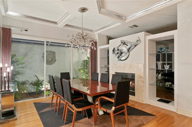 dining area featuring visible vents, coffered ceiling, wood finished floors, and a fireplace