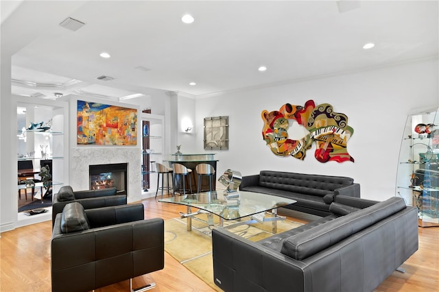 living room featuring recessed lighting, visible vents, light wood-style floors, and ornamental molding