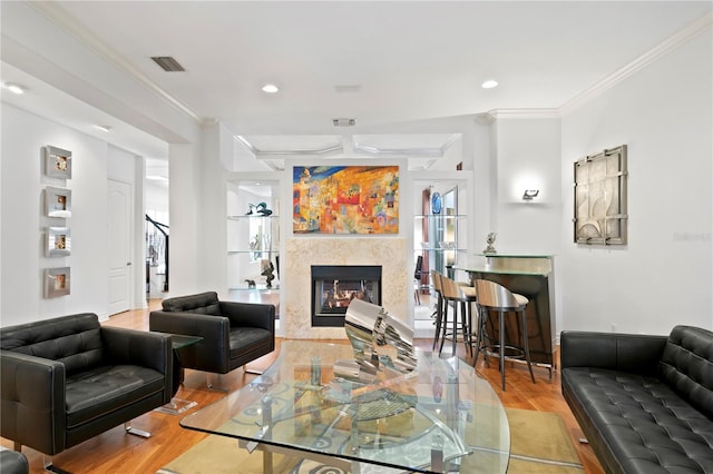 living room with a premium fireplace, recessed lighting, crown molding, and wood finished floors