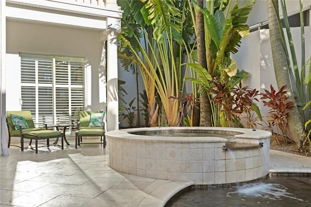 view of patio / terrace featuring an outdoor hot tub