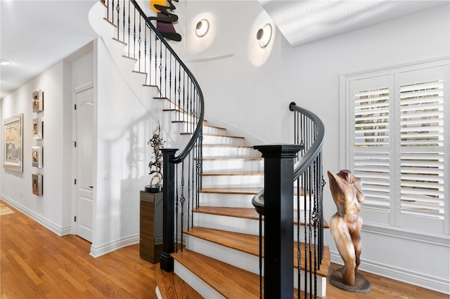 stairs with baseboards and wood finished floors