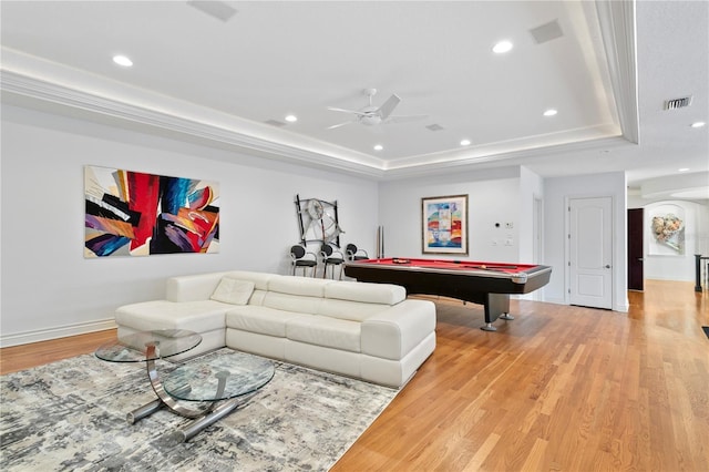 playroom featuring light wood finished floors, visible vents, ceiling fan, and a tray ceiling