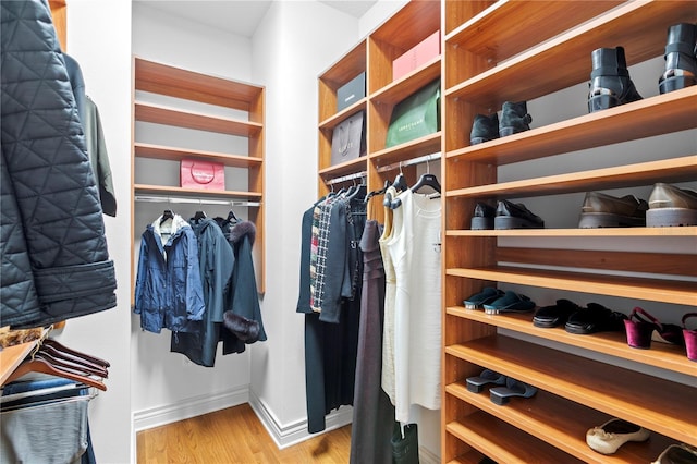 walk in closet with wood finished floors