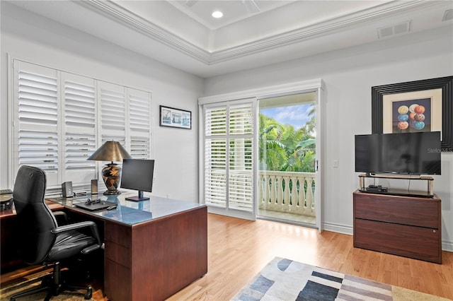 office with visible vents, light wood finished floors, recessed lighting, ornamental molding, and a raised ceiling