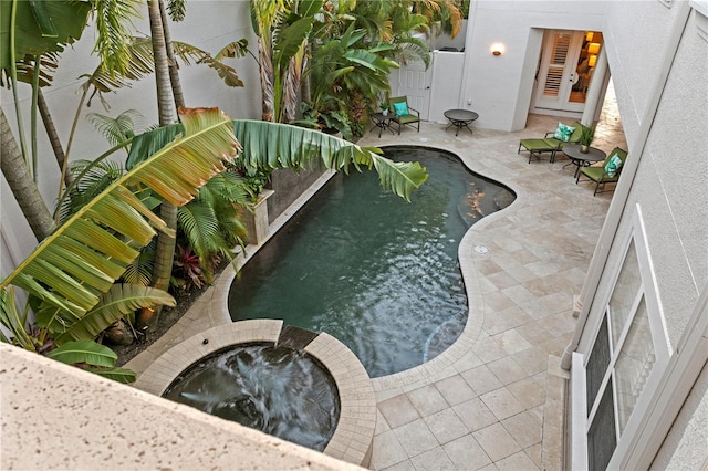 view of swimming pool with a pool with connected hot tub and a patio area