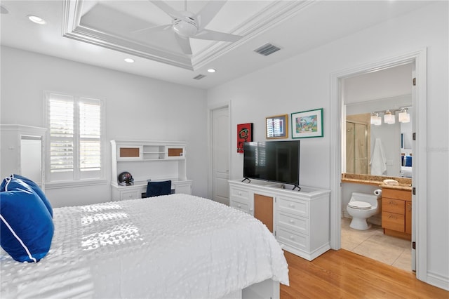 bedroom with visible vents, ornamental molding, recessed lighting, light wood finished floors, and a raised ceiling