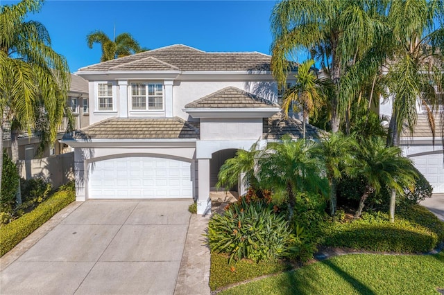 view of front of home featuring a tile roof, driveway, and stucco siding