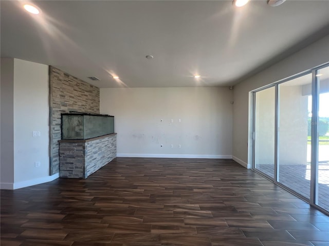 unfurnished living room with visible vents, dark wood-style floors, and baseboards