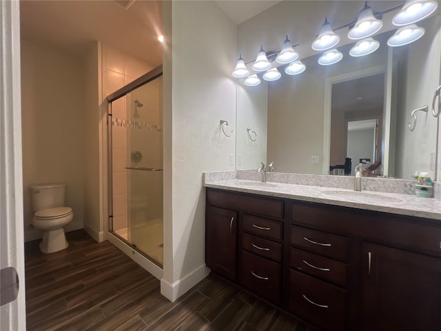 full bath featuring a stall shower, toilet, wood finish floors, and a sink