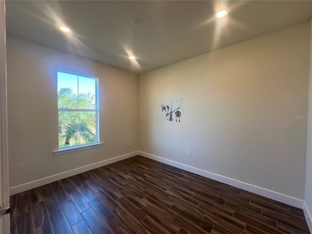 empty room featuring recessed lighting, baseboards, and dark wood finished floors