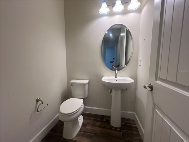 bathroom featuring wood finish floors, toilet, and baseboards