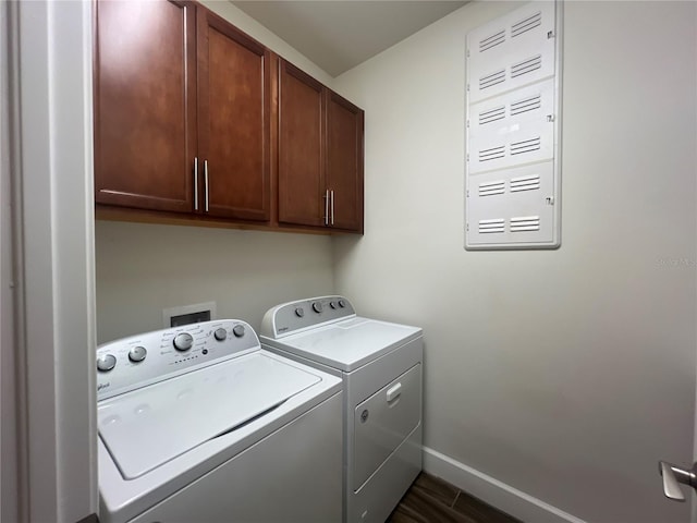 laundry room featuring baseboards, cabinet space, dark wood finished floors, and washer and clothes dryer