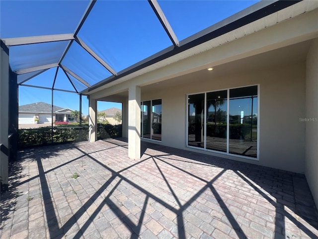 view of patio featuring glass enclosure