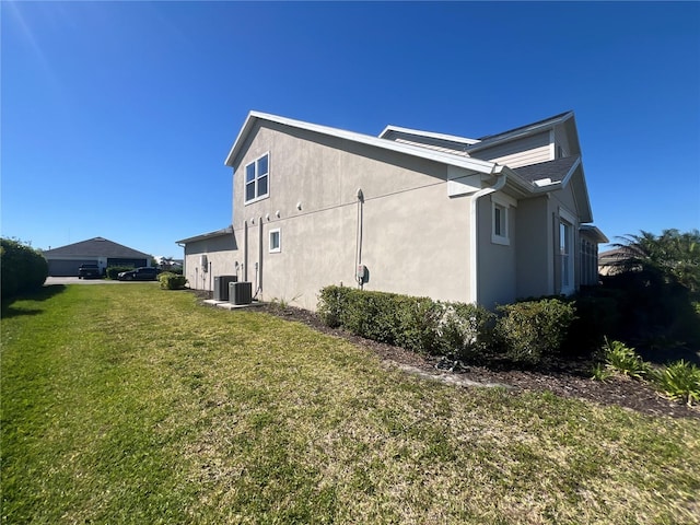 view of home's exterior featuring central air condition unit, a yard, and stucco siding