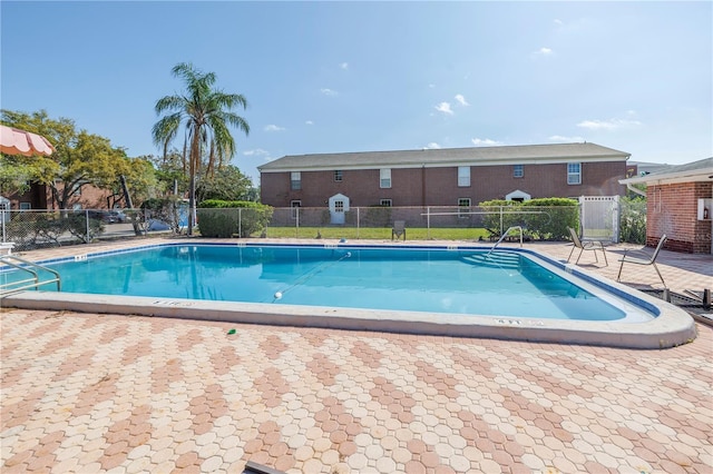 pool with a patio and fence