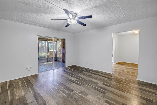 empty room featuring baseboards, a textured ceiling, ceiling fan, and wood finished floors