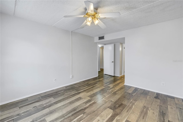 unfurnished room featuring wood finished floors, a ceiling fan, visible vents, baseboards, and a textured ceiling