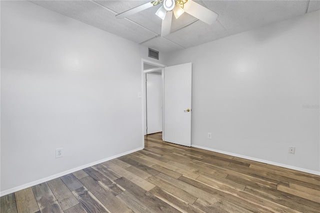 unfurnished room featuring visible vents, baseboards, a ceiling fan, and wood finished floors