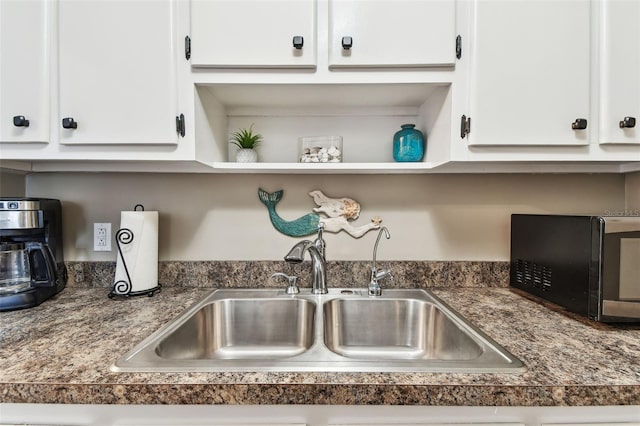 details with open shelves, white cabinetry, and a sink