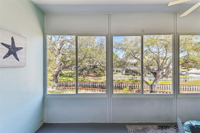 unfurnished sunroom with a ceiling fan