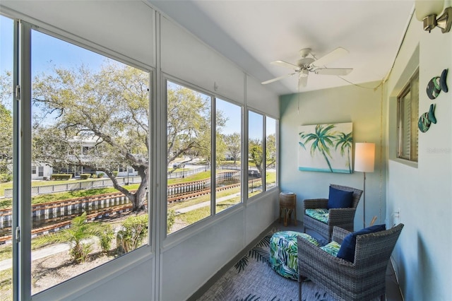 sunroom / solarium featuring a ceiling fan