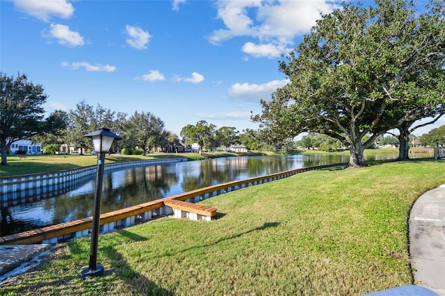 exterior space with a water view and a lawn