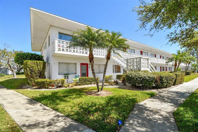 townhome / multi-family property featuring a front yard and stucco siding