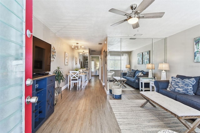 8220 112th St N Unit 206, Seminole, FL 33772 - living area with ceiling fan, light wood-style floors, and baseboards