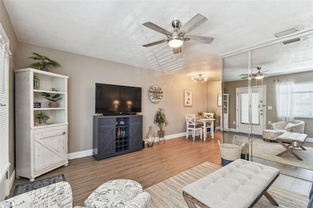 8220 112th St N Unit 206, Seminole, FL 33772 - living area featuring a ceiling fan, wood finished floors, baseboards, and a textured ceiling