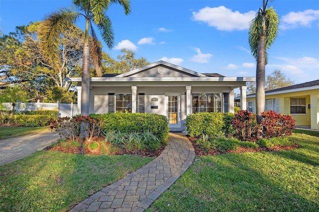 view of front of house with stucco siding, a front lawn, and fence