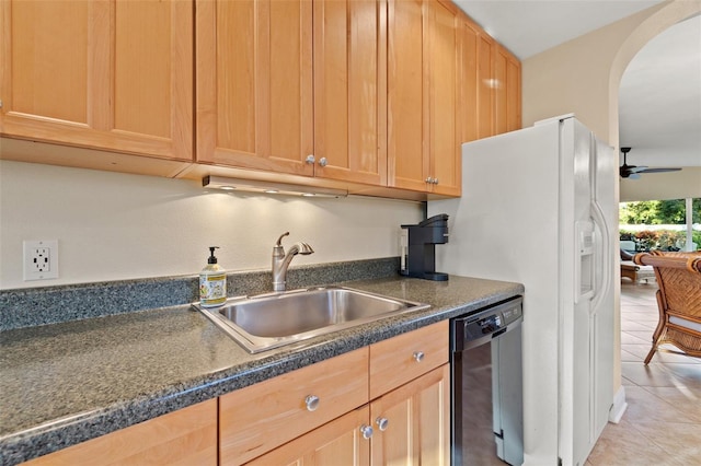 kitchen featuring dark countertops, dishwasher, arched walkways, and a sink