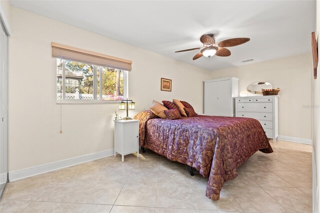 bedroom featuring light tile patterned floors, baseboards, visible vents, and ceiling fan