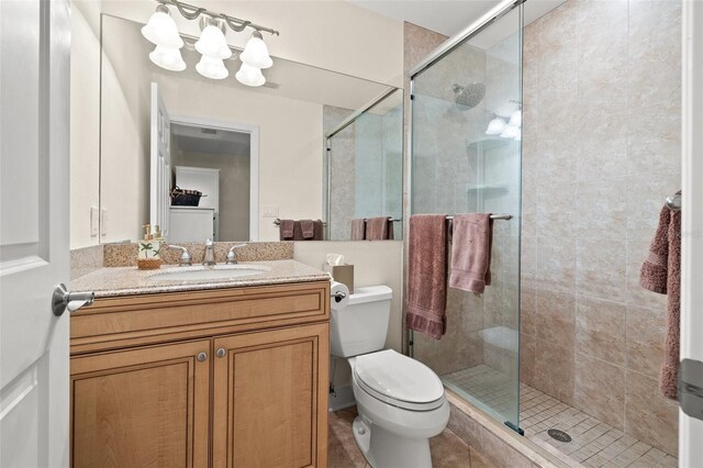 full bathroom featuring vanity, a shower stall, and toilet