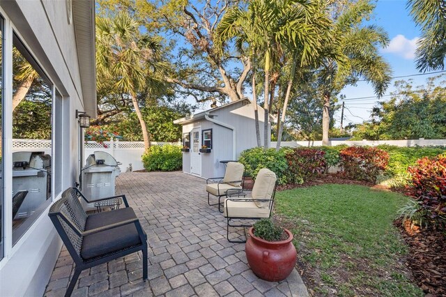 view of patio featuring an outbuilding and fence