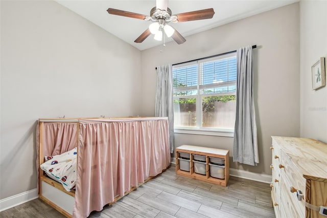 bedroom with a ceiling fan, light wood-style floors, and baseboards