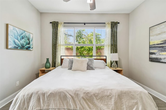 bedroom featuring a ceiling fan, baseboards, and wood finished floors