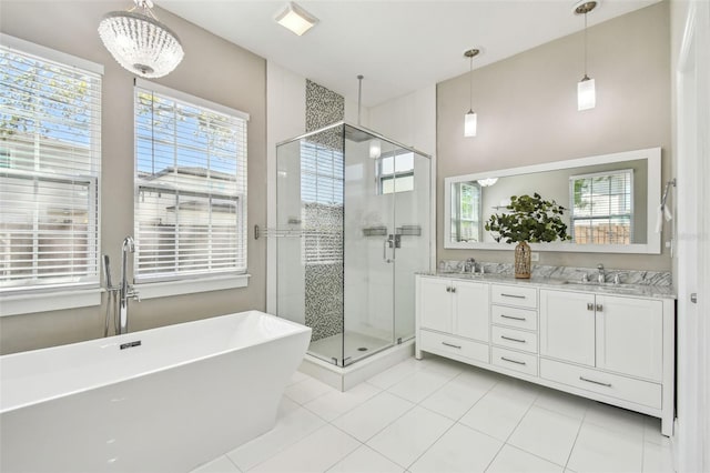 full bathroom with a sink, a freestanding bath, double vanity, and a shower stall