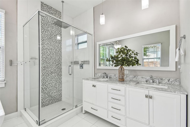 bathroom featuring plenty of natural light, a shower stall, and a sink