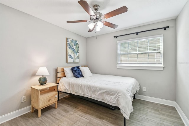 bedroom with baseboards, ceiling fan, and light wood finished floors