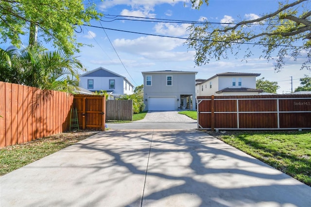 exterior space with an attached garage, concrete driveway, and fence